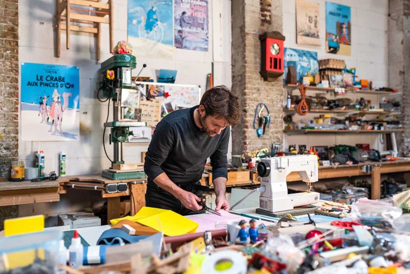 Designer cutting fabric in studio