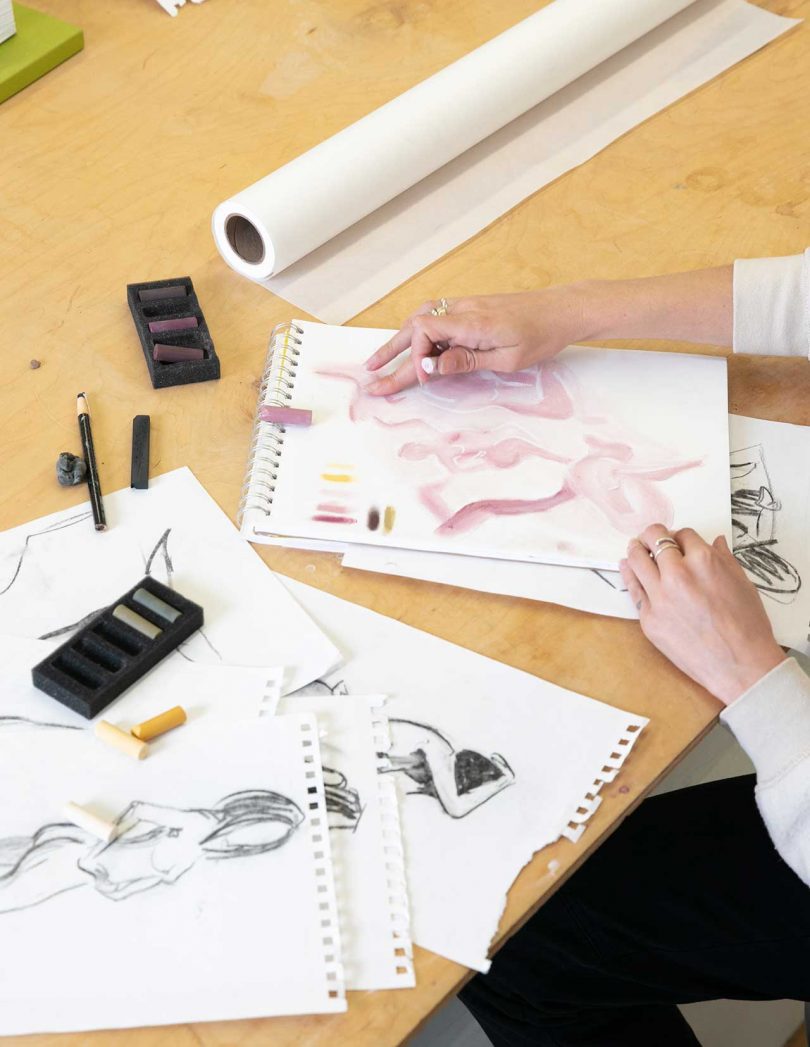 artist's hands sketching on paper