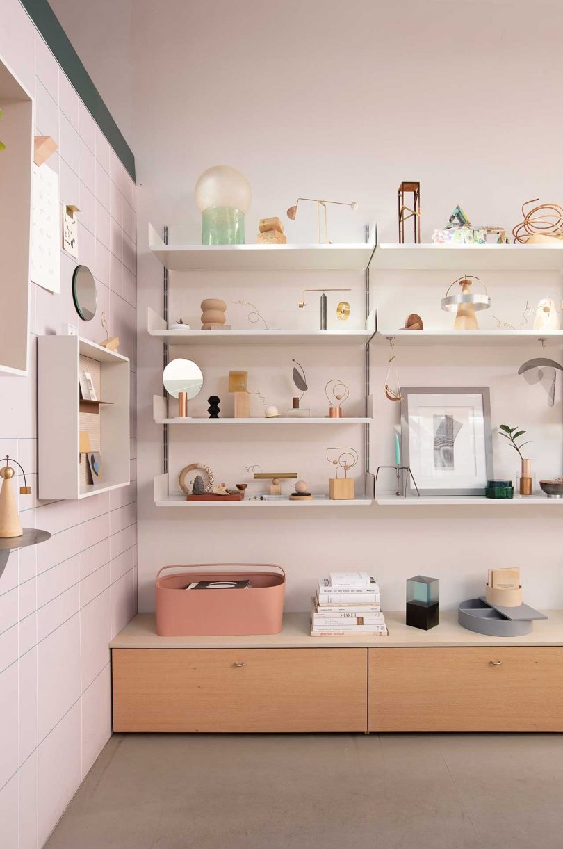 office with pink walls and shelves with design objects and art