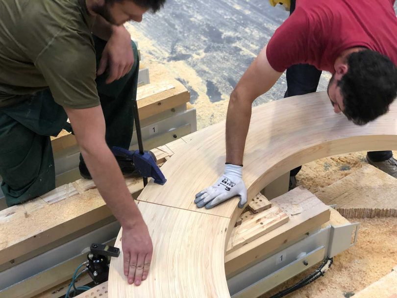 fitting curved wooden components together in shop