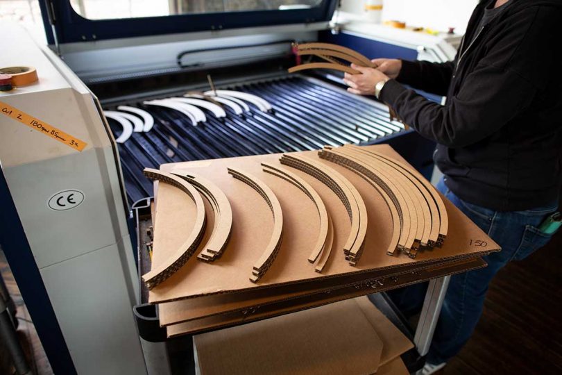 piles of curved cardboard strips just cut on the laser cutting machine