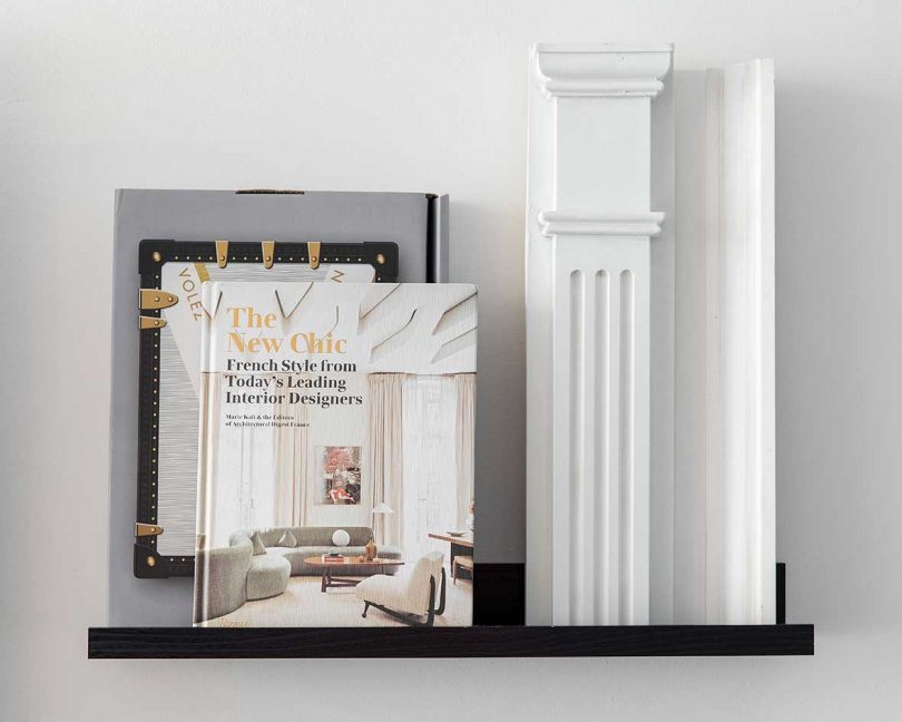 wall shelf holding books propped against wall