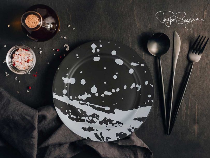 place setting with splattered dinner plate in black and white with black silverware