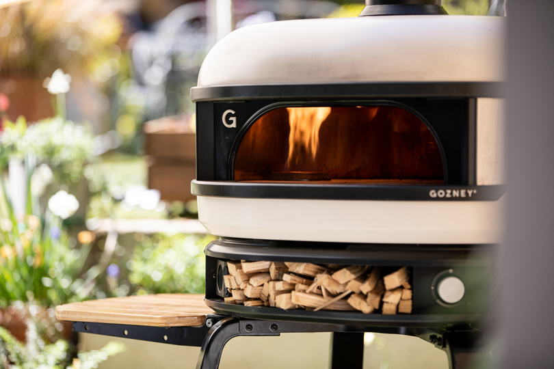 white pizza oven with wood and flame