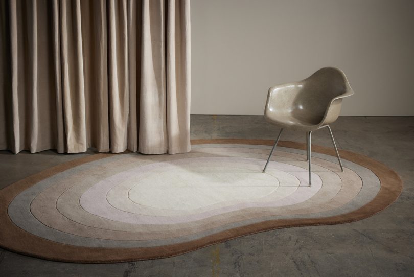 brown and cream floor rug in styled living space with armchair and curtain