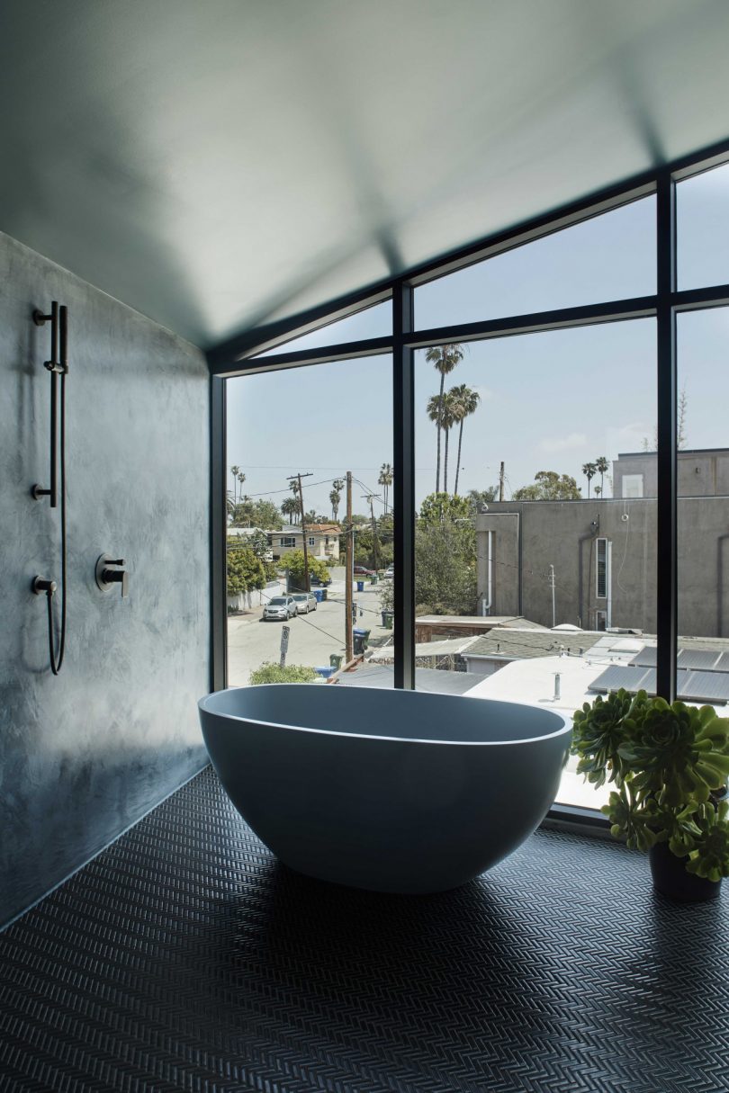 interior view of modern bathroom with oval tub in front of wall of windows