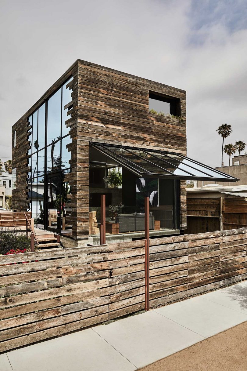 exterior view of modern guesthouse with aged wood exterior and open window