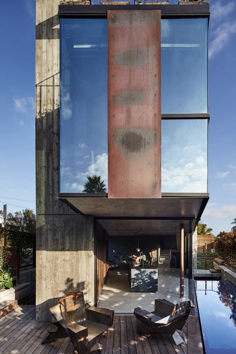 closeup exterior side view of modern industrial house with mirrored windows and rusted iron details