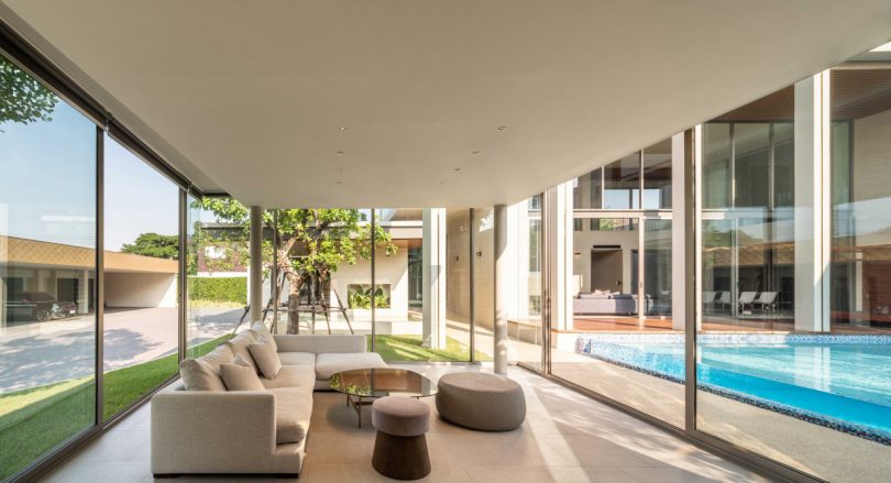 interior living room of Bangkok house with seating facing blue swimming pool