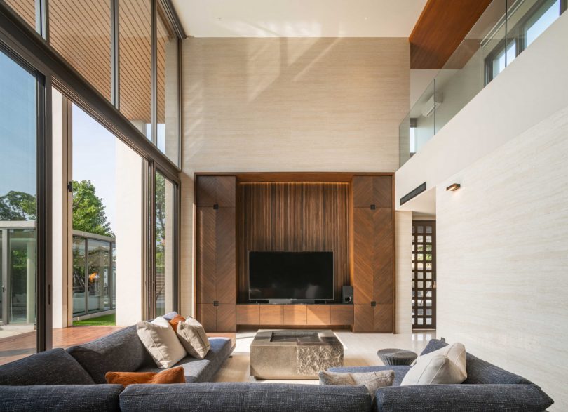 interior shot of modern double-height living rom with l-shaped sofa looking to TV