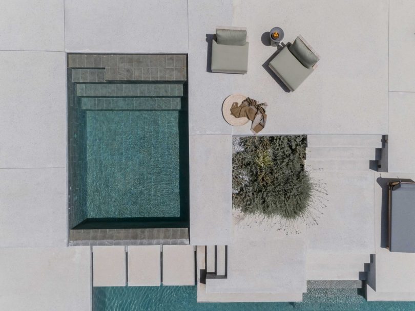 sky view looking down to a modern backyard patio with seating and swimming pool