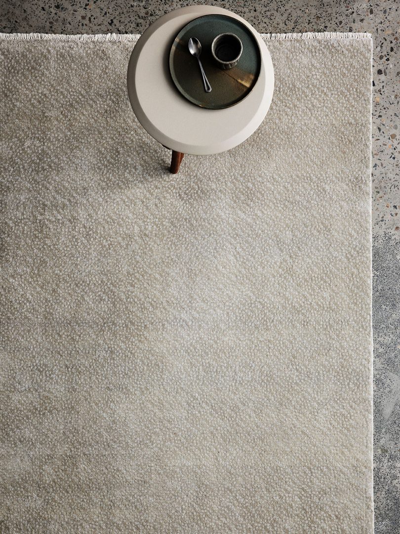 overhead shot of neutral tone floor rug and side table