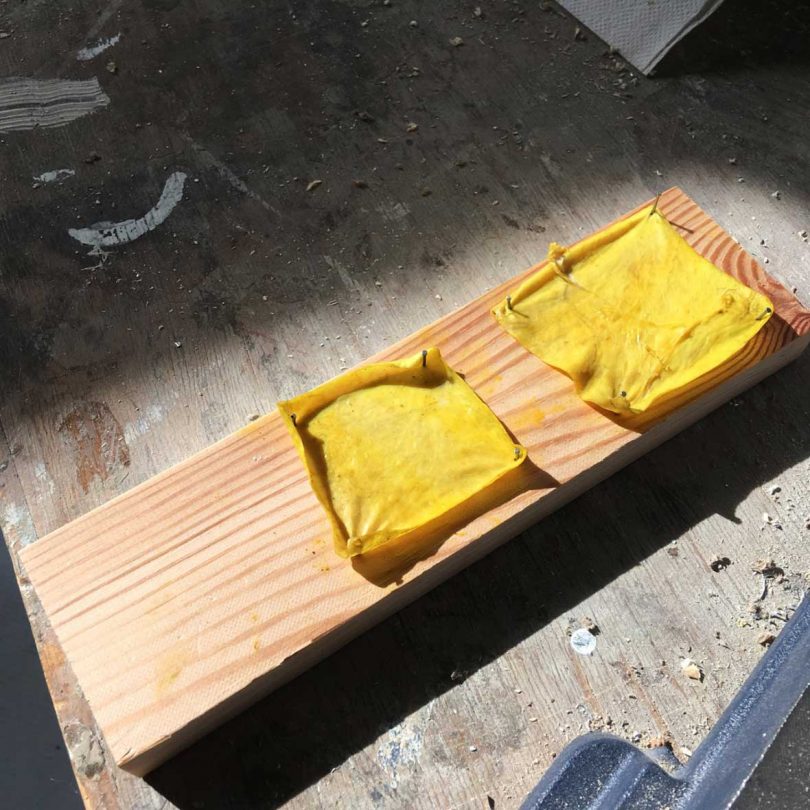 two ruffled yellow squares resting on wood board