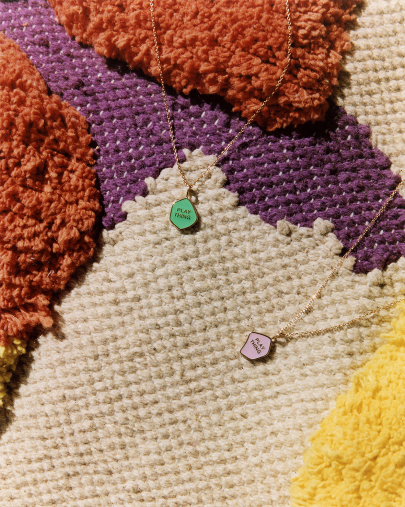 two pendant necklaces on a colorful rug