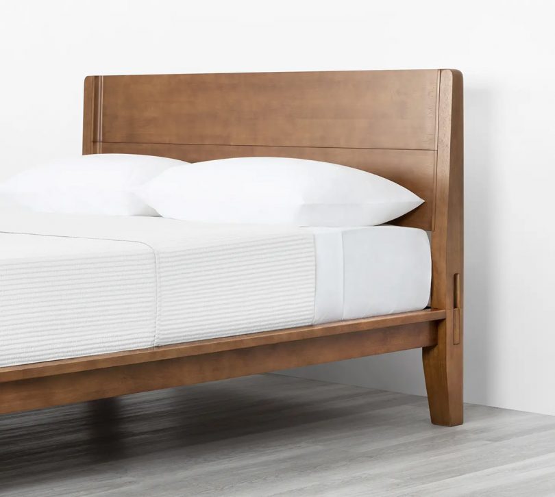 simple walnut wood bed frame and headboard with white bedding