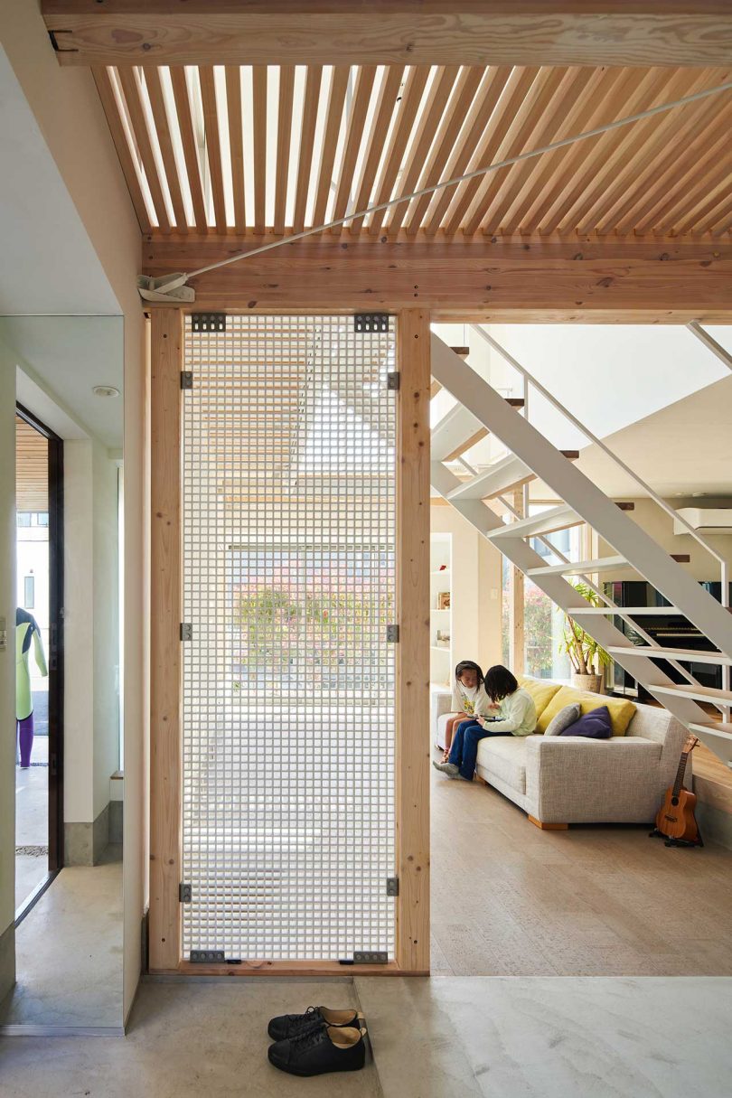 interior of modern Japanese home looking through doorway to living room with white open stairs