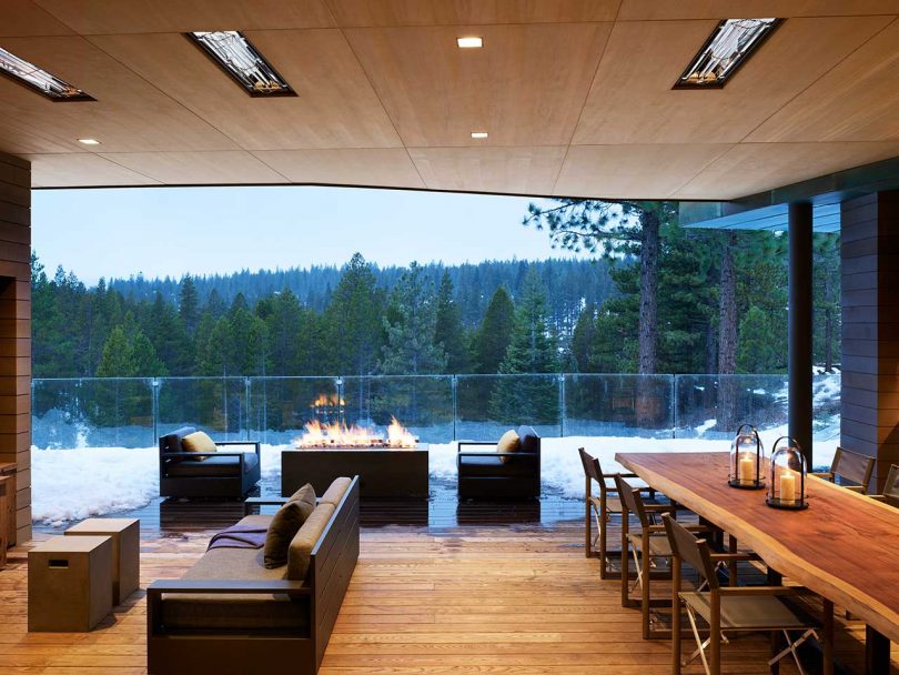 covered patio view of large modern house with outdoor furniture and views of snowy landscape