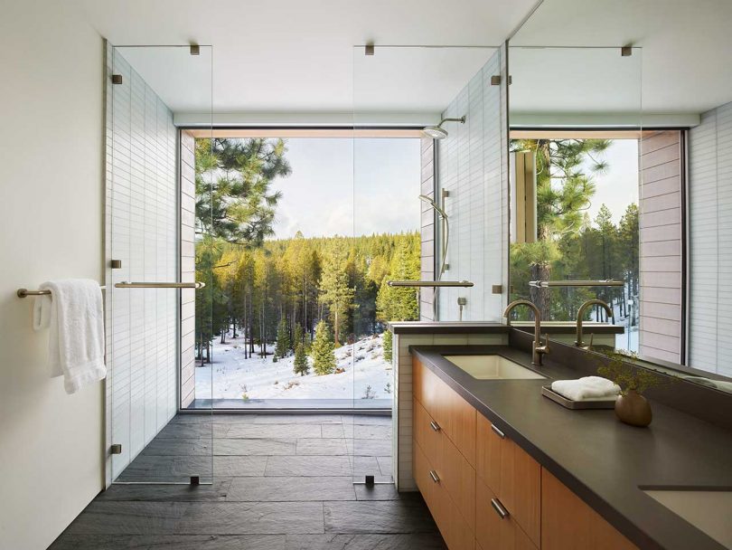 interior shot of modern bathroom looking through shower to large window wall