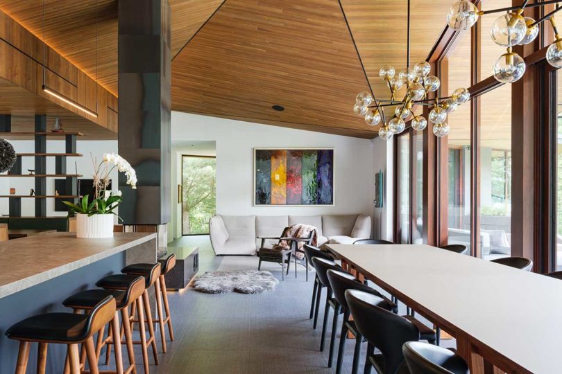 long interior view of modern home open living space with kitchen and dining room looking into the living room