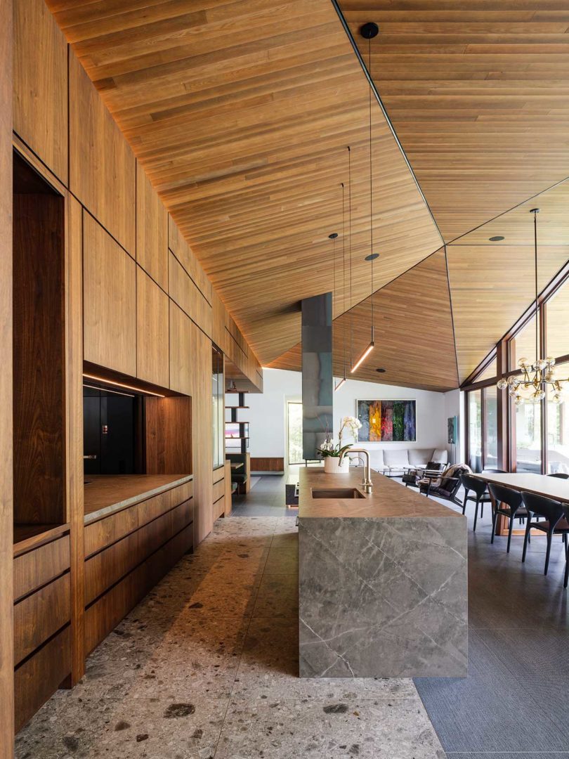 long interior view of modern home open living space with kitchen and dining room looking into the living room