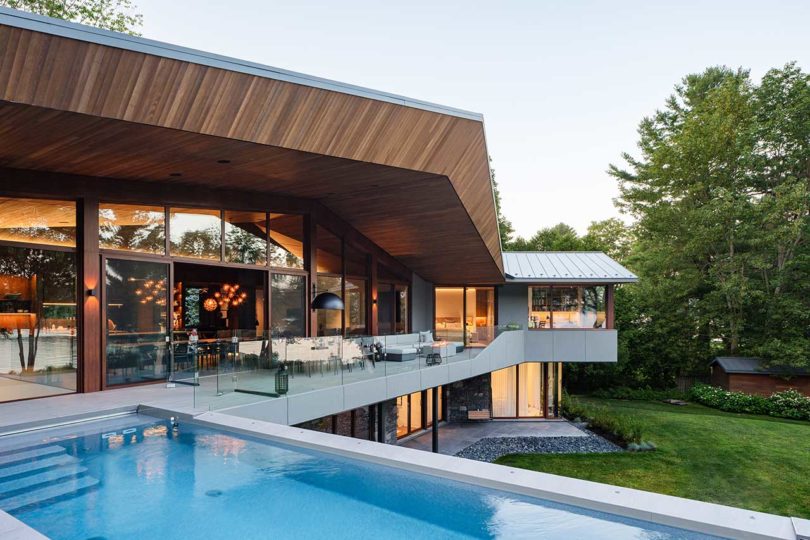 evening view of modern home exterior deck with swimming pool