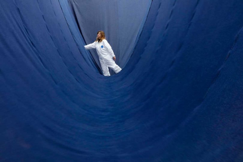 Woman stands in Paola Pivi's sculpture Free Land Scape