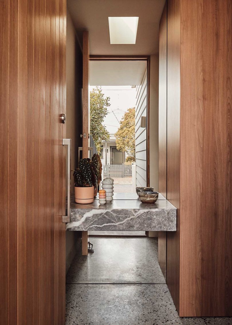 wood hallway looking into mirror with marble shelf