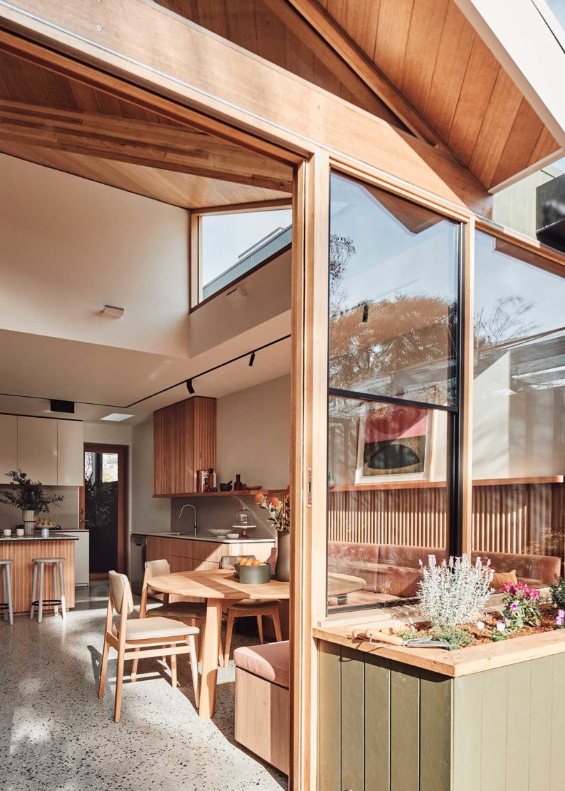 angled exterior view of modern house looking in through the back door into the eating area and kitchen