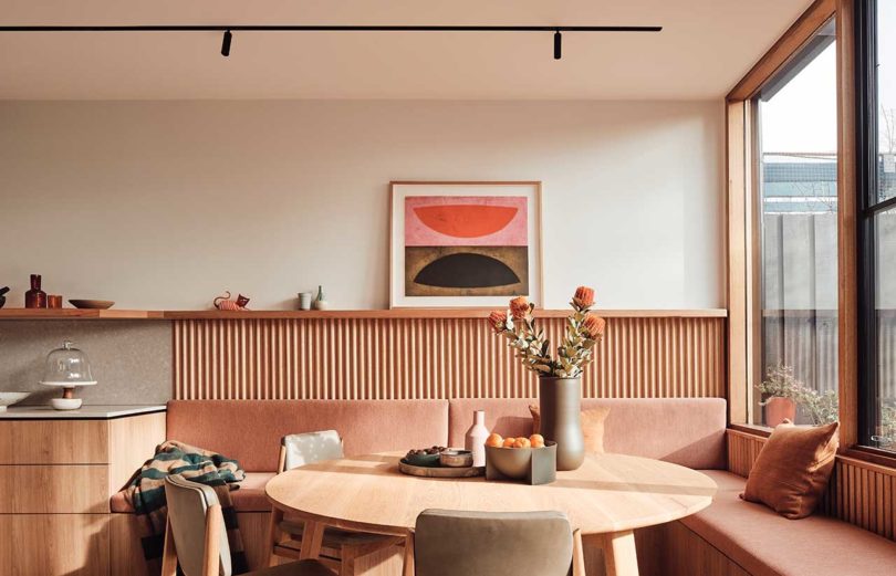 interior view of modern dining area with wood table and built-in seating