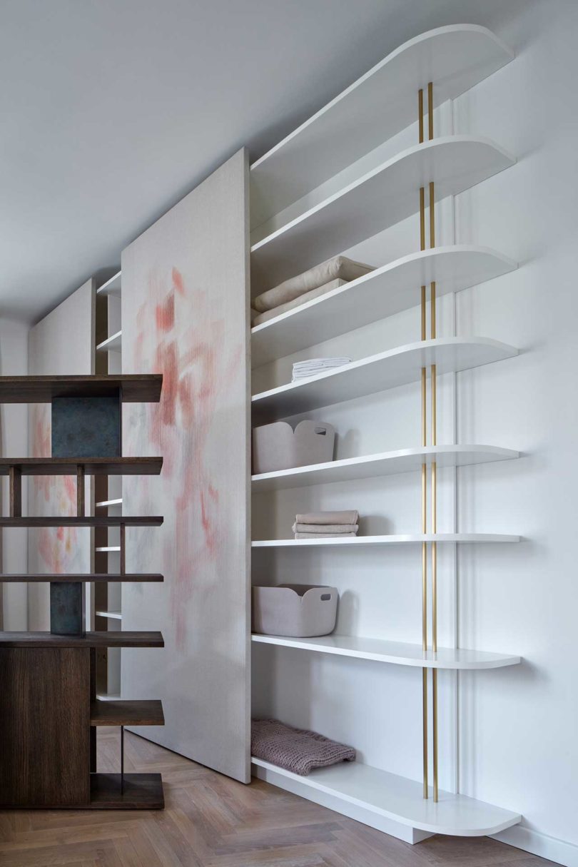 side view of modern wall mount book shelf with sliding painting overing it