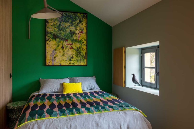 simple modern bedroom with turquoise walls and patterned bedding