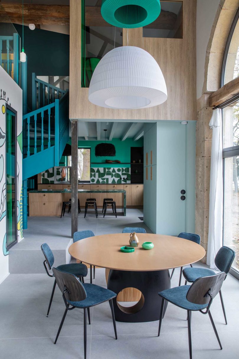 view from dining room to turquoise kitchen in distance in modern home