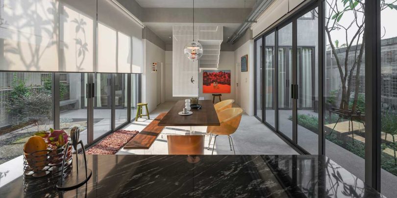 interior shot of modern home dining room flanked by walls of windows