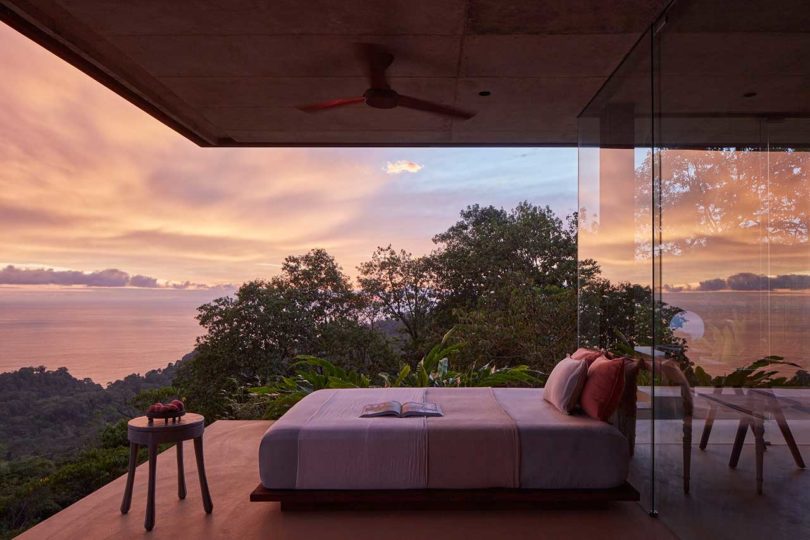 side view of bed on veranda of modern villa in tropical locale