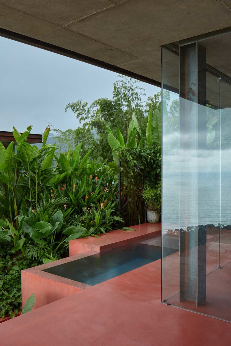 modern villa with red floors looking out to tropical landscape