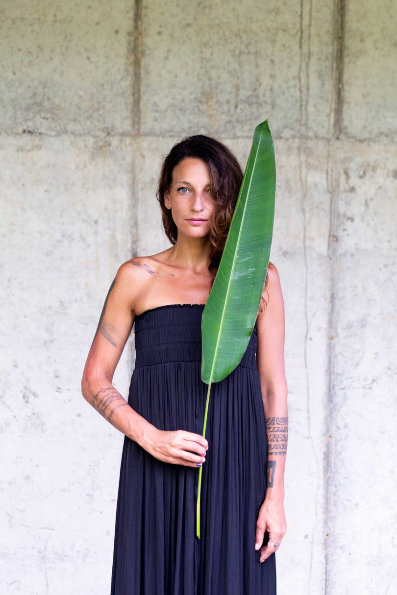 Woman standing holding a long palm leaf