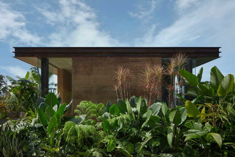 Side of cliffside villa with green plants in front