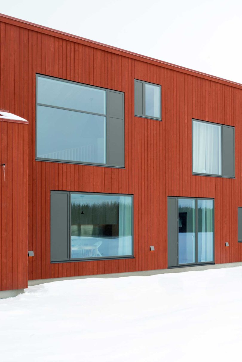 exterior view of modern red house in snow