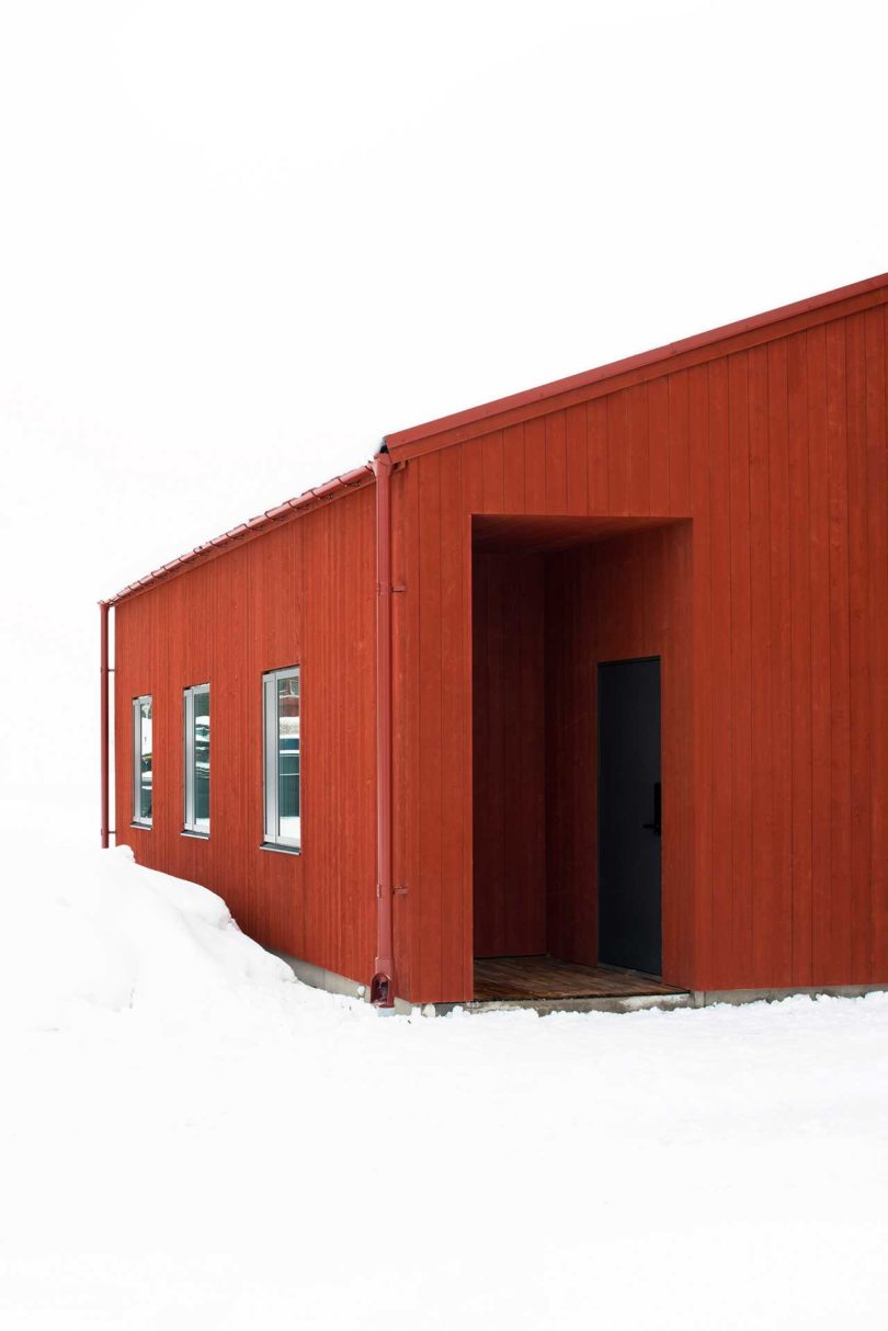 exterior view of modern red house in snow