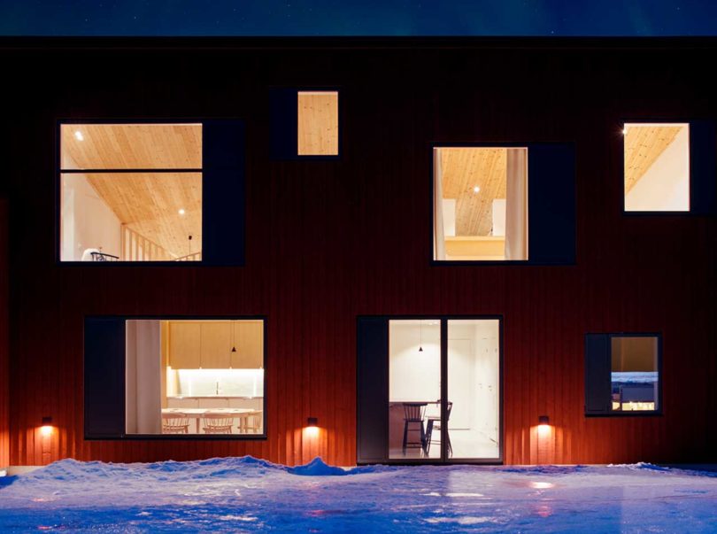 exterior view of modern red house in snow at night