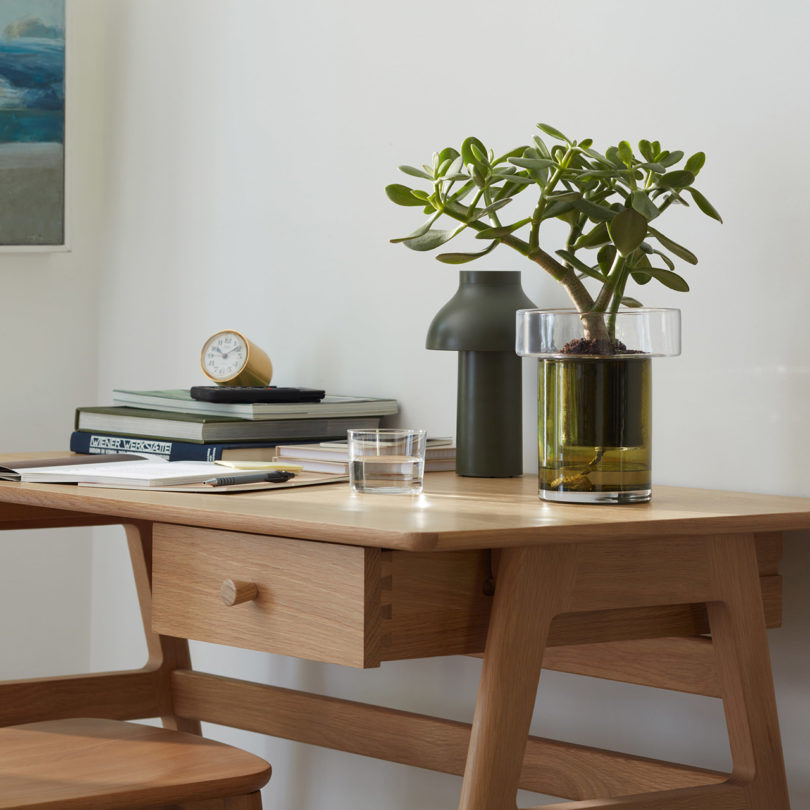 self-watering glass planter on a desk