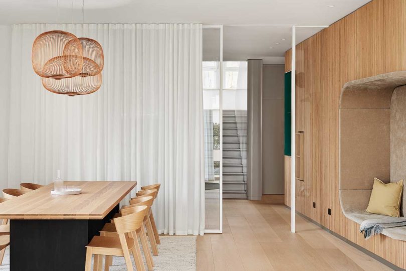 interior of modern home with wooden details and dining table with copper wire pendants