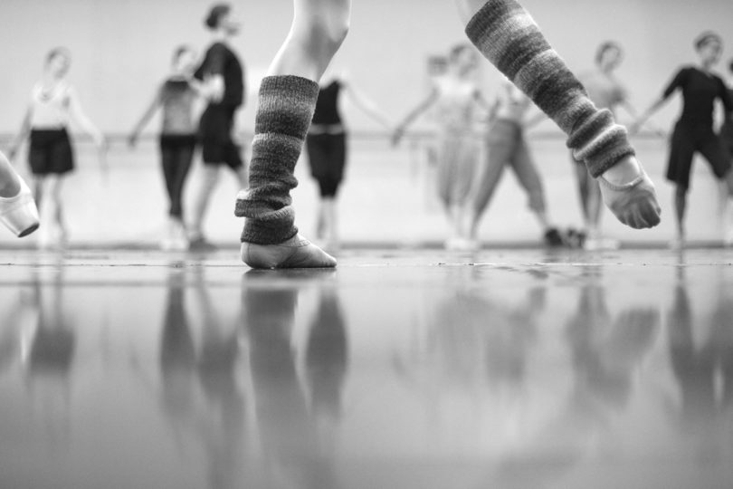 black and white low angle image of ballet dancers warming up