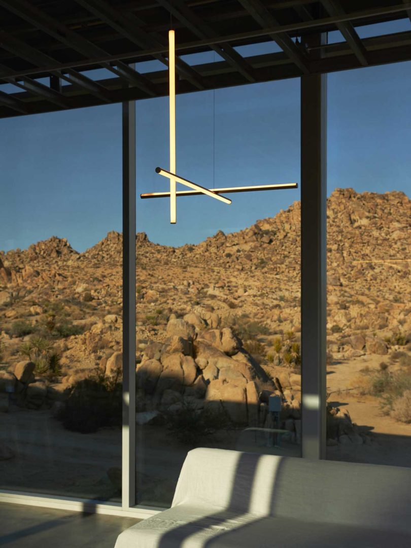 interior view of modern house with linear light fixture looking out to rocky hill