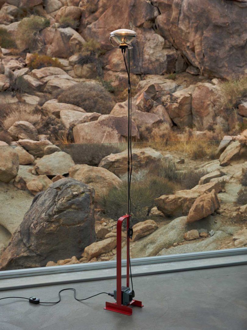 interior shot of modern light fixture in front of window with rocky landscape beyond