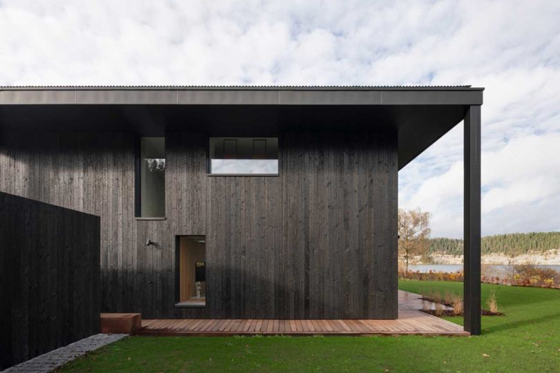 partial exterior view of modern black lake house