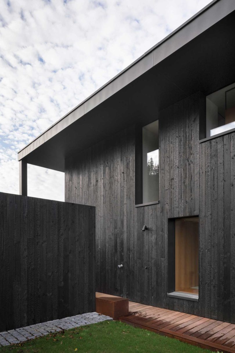 angled side view of modern black lake house