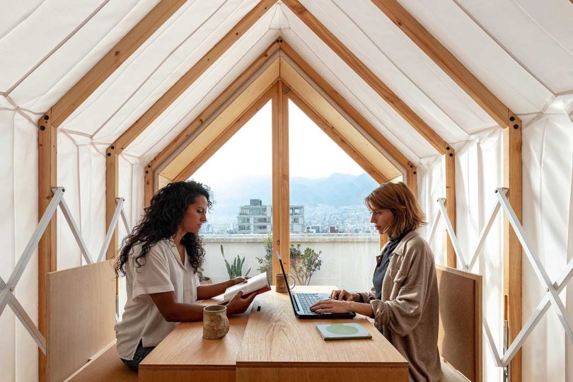 interior view of expandable shelter with two women sitting at table