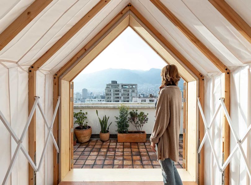 interior view of expandable shelter looking out with woman standing at entry