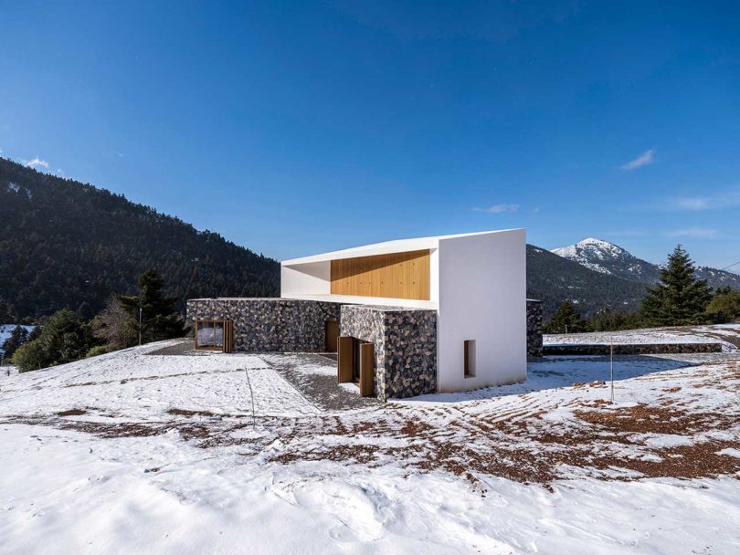 angled ground view of modern stone and white mountain house